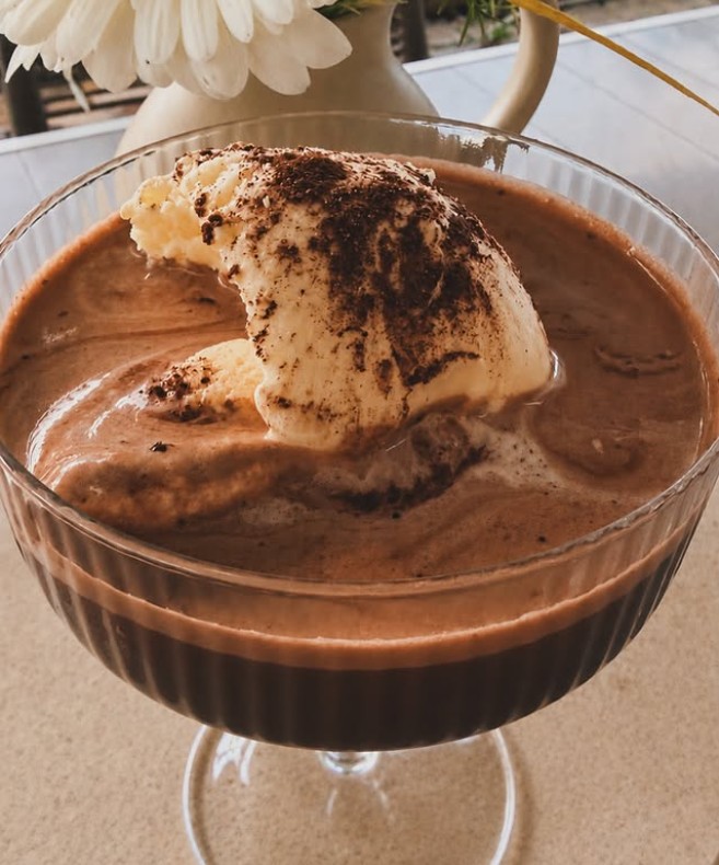 Chocolate affogato in a fluted glass dusted with cocoa